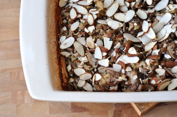 White casserole dish full of a wild rice mix and topped with sliced almonds.
