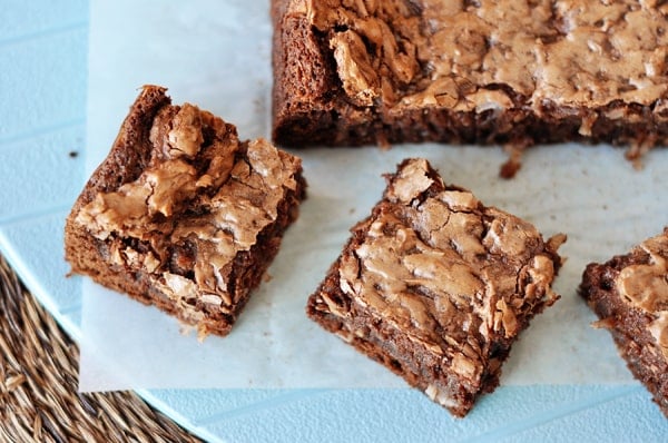 Top view of small squares of brownies cut off a big slab of brownie.