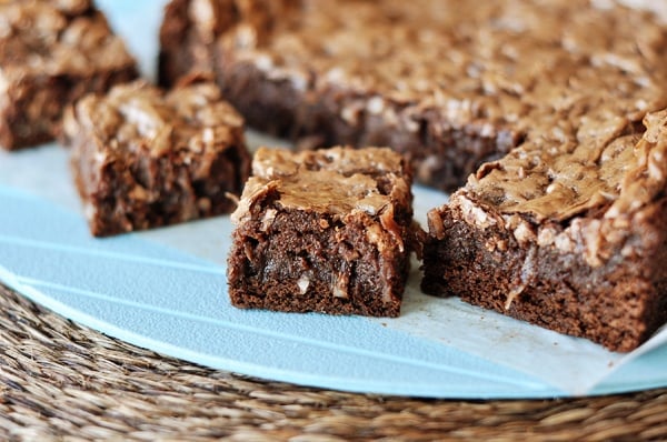 A slab of gooey chocolate brownies with a few small squares cut out.