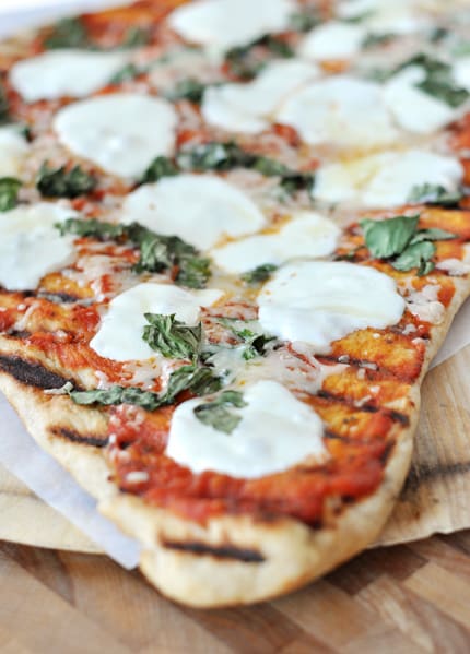 A grilled pizza with fresh mozzarella melted on top.