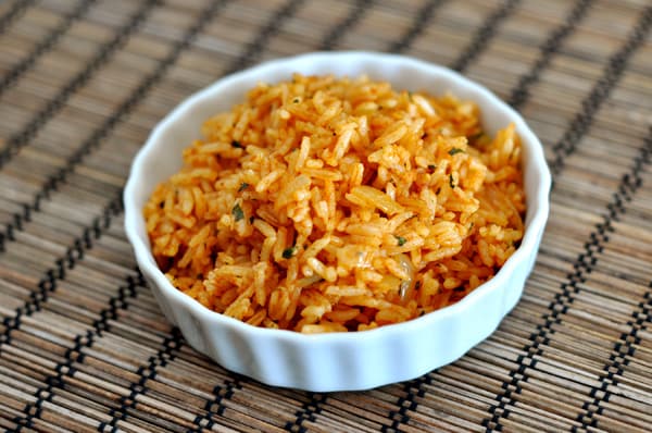 A small white ramekin filled with Mexican rice.