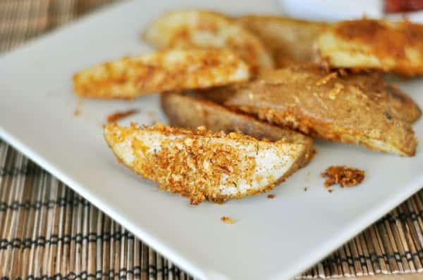 White rectangular platter with baked panko-crusted potato wedges.