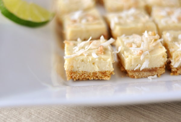 White platter with toasted coconut-topped key lime bars cut into small squares.
