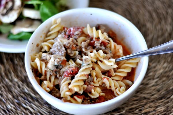 Top view of a white bowl of lasagna soup filled with cooked spiral noodles.