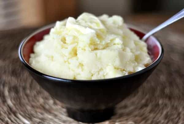 Mashed potatoes in a black bowl.