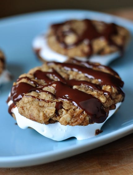 Two chocolate drizzled homemade moon pies on a blue plate.