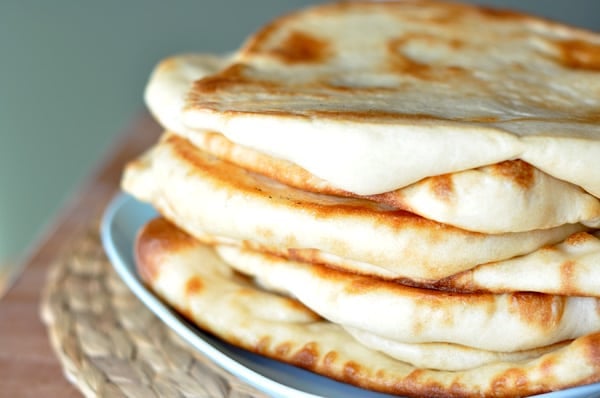 A blue plate with stacked cooked flatbread.