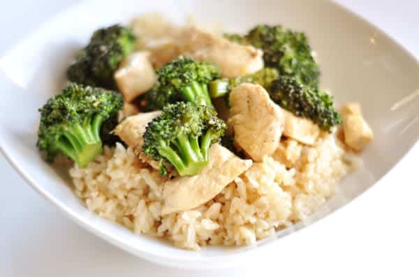 White bowl with rice, chicken pieces, and broccoli.