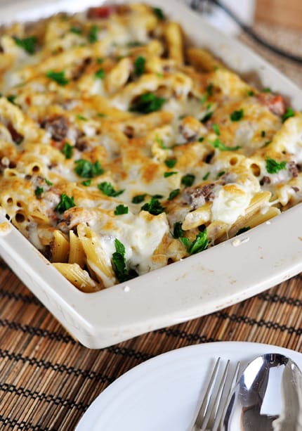 White casserole dish with a baked, cheese-topped, pastitsio Greek pasta.