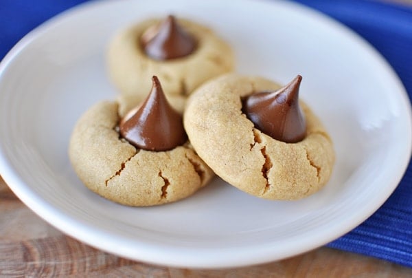 White plate with three Hershey Kiss topped peanut butter cookies.