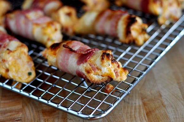 Bacon wrapped cheese bites on a cooling rack.