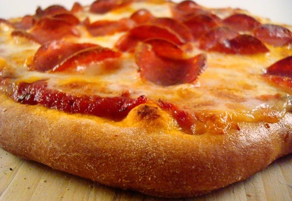 Side view of cooked pepperoni pizza.