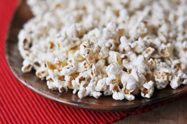 Popped popcorn on a brown plate.
