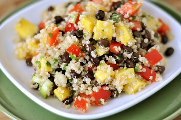 White plate with mango and quinoa black bean salad.