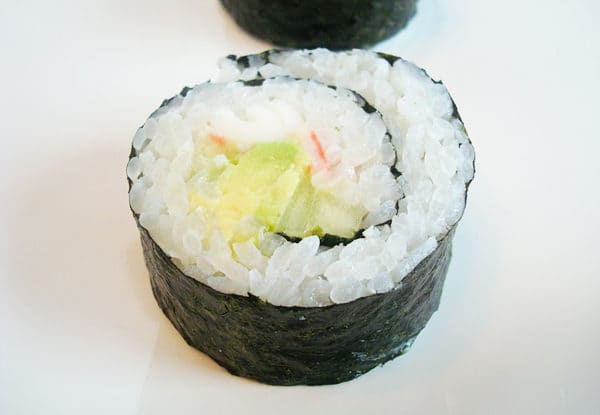 top view of a california sushi roll on a white plate