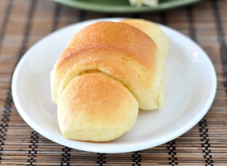 A small white plate with a golden brown cooked crescent roll.