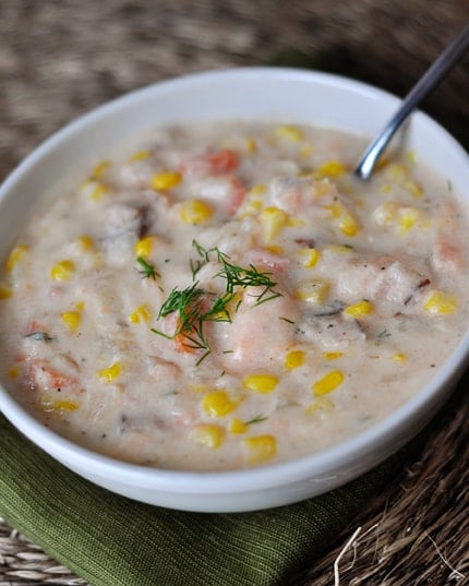 Top view of a white bowl of salmon corn chowder.