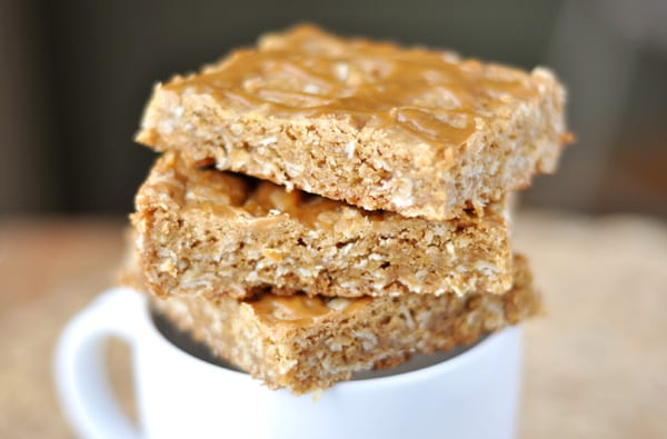 Oatmeal butterscotch bars stacked on a white mug.