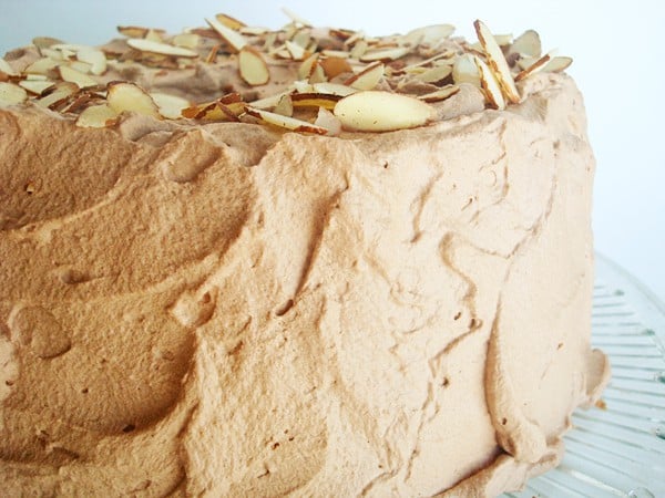 Angel food cake with chocolate whipped frosting and topped with sliced almonds.
