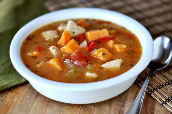 White bowl full of chicken and sweet potato soup.