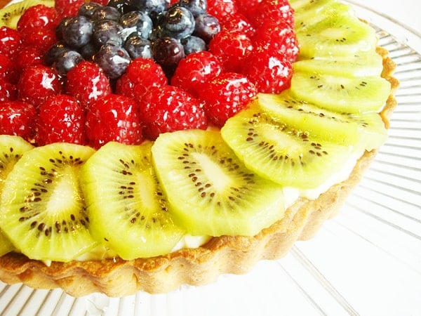 Tart with frosting and fresh fruit on top.