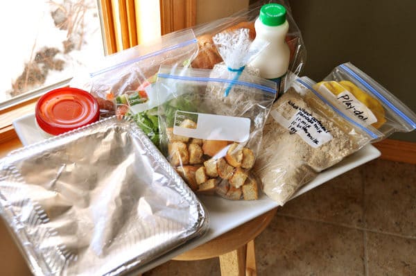 a big white tray full of various bagged foods and sides to use as a take-in meal