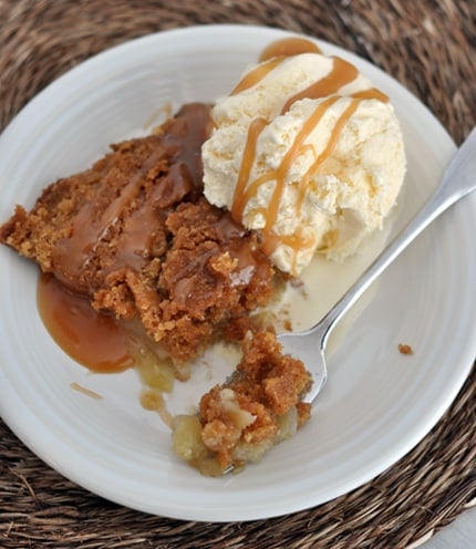 Top view of a piece of apple pie next to a scoop of vanilla ice cream.