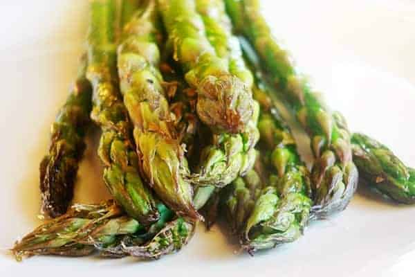 Roasted asparagus on a white plate.