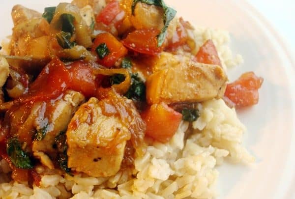 White rice with stir fried vegetables and chicken on top.