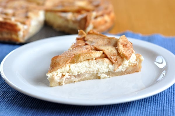 A slice of apple torte on a white plate.