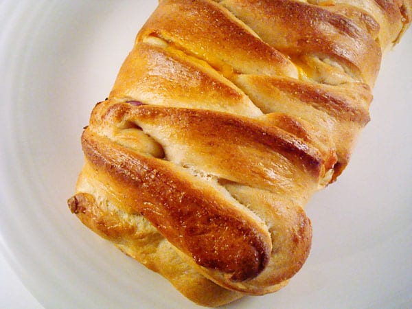 Braided bread loaf on a white plate.