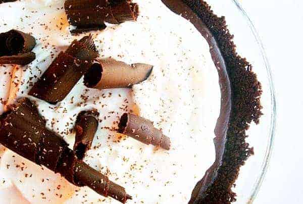 Top view of a pie with chocolate crust, whipped cream, and chocolate curls.