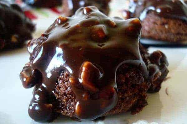 Brownie bite with chocolate glaze on a white plate.