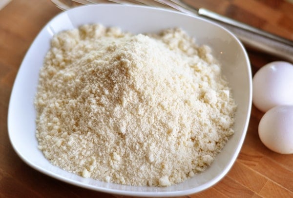 White bowl with dry cake mix and two eggs on the side of the bowl.