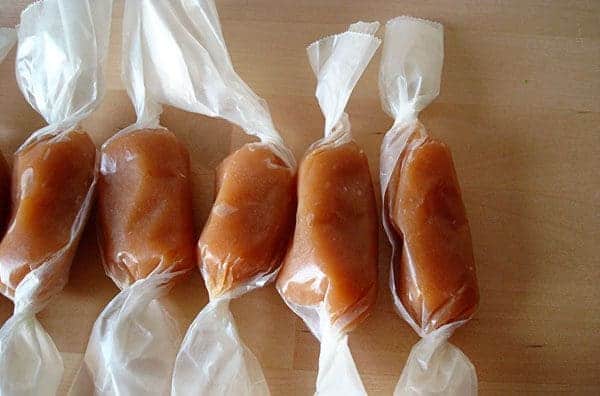 Caramels wrapped in wrappers lined up in a row.