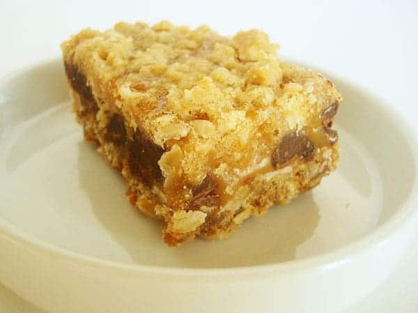 Oatmeal chocolate chip caramel bar on a white plate.