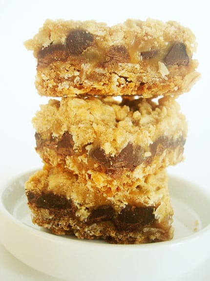 Stack of oatmeal chocolate chip caramel bars on a white plate.