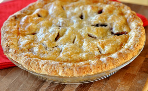 Top view of a baked cherry pie with a golden brown crust.