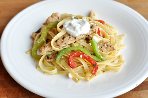 Cooked pasta, bell pepper slices, and grilled chicken on a white plate.