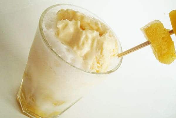 top view of a clear glass full of a pineapple ice cream float