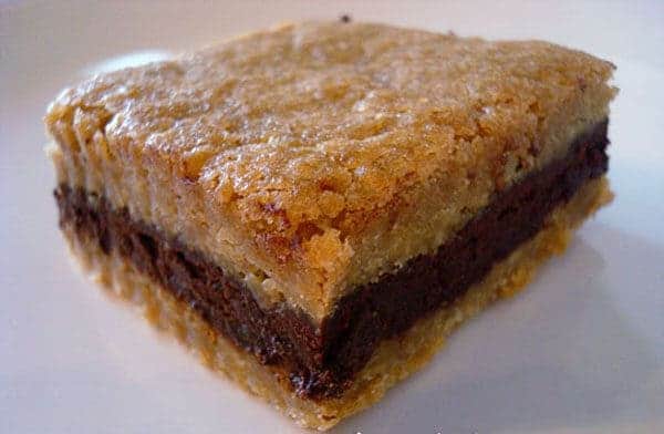 Brown sugar bar with a dark chocolate layer on a white plate.