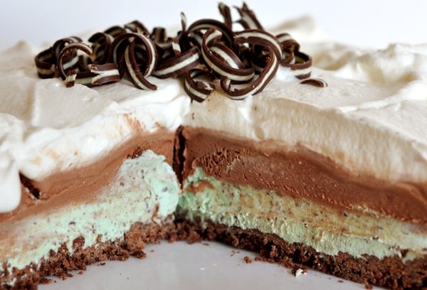 A mint and chocolate ice cream pie with a big piece taken out.