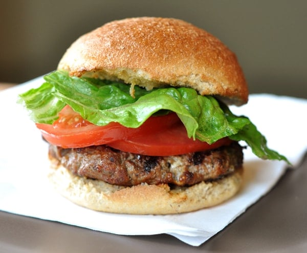 Hamburger with sliced tomato and lettuce on a toasted hamburger bun.