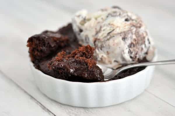 Small white ramekin with chocolate cake and a scoop of ice cream in it.