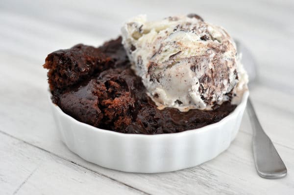 White ramekin with chocolate pudding cake a scoop of ice cream.