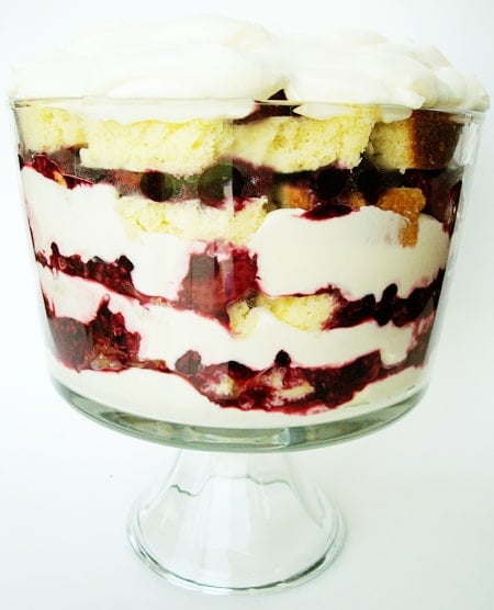 Clear trifle dish with layers of lemon pound cake, berry, and whipped cream.
