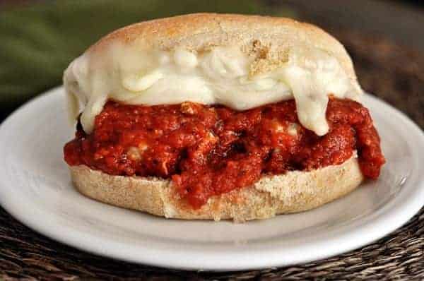 Meatball and cheese sub sandwich on a white plate.