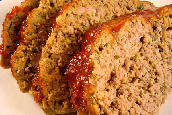 Thick meatloaf slices on a white plate.