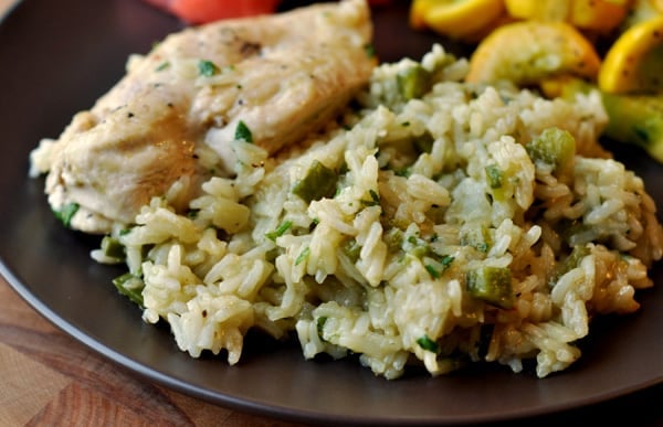 Black plate with Mexican rice and slices of chicken.