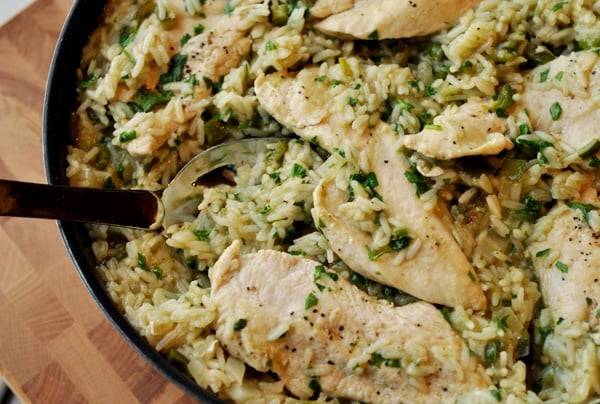 Dark skillet filled with Mexican rice and strips of cooked chicken.